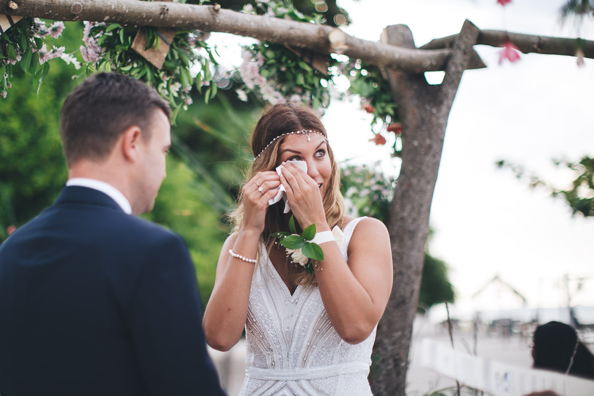 bride wipes a tear from her eye during the wedding ceremony