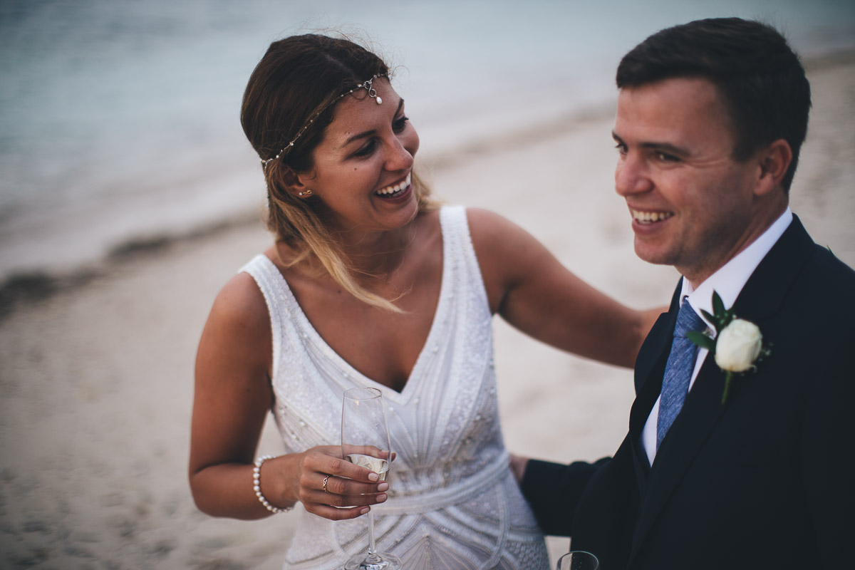 wedding portrait of couple laughing on beach