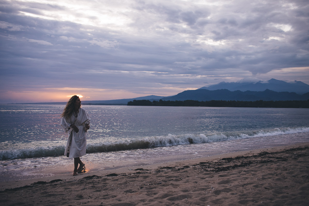 bride picking shells at sunrise after the wedding