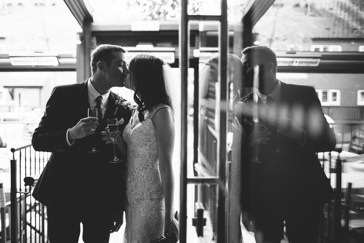 reflection of bride and groom kissing