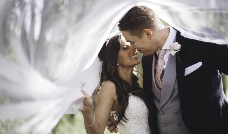 bride and groom kiss under veil