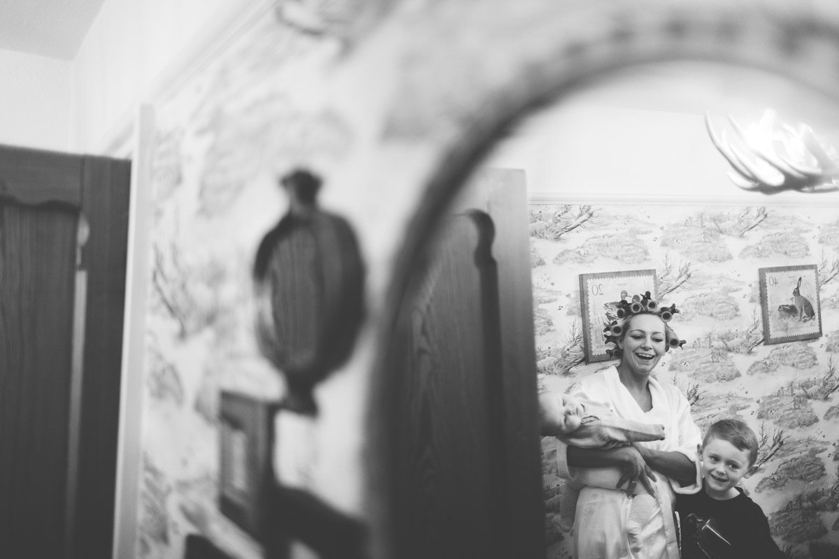 bride in rollers through mirror