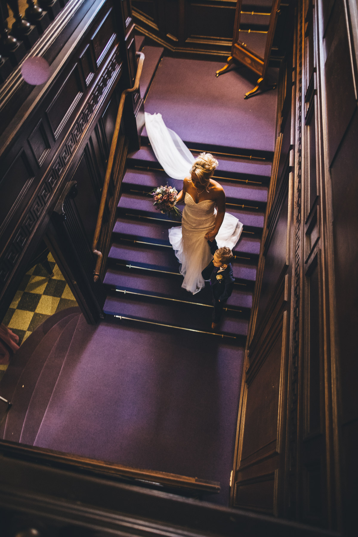 bride walking down purple stairs with son