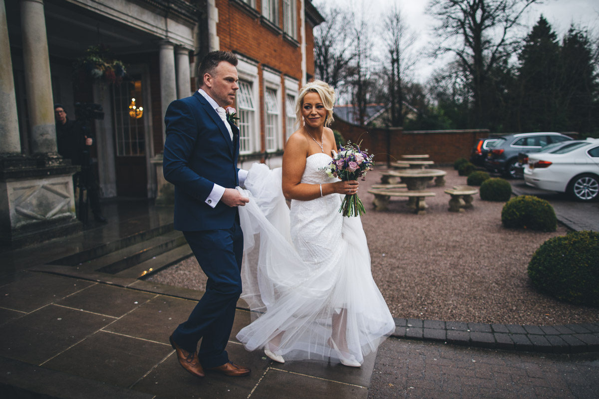 bride and groom take a walk in the rain
