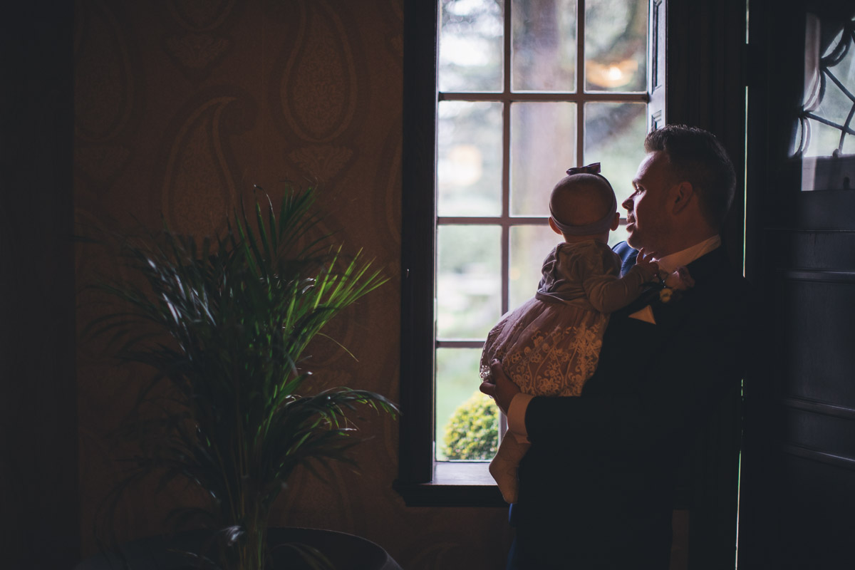 groom holds baby daughter