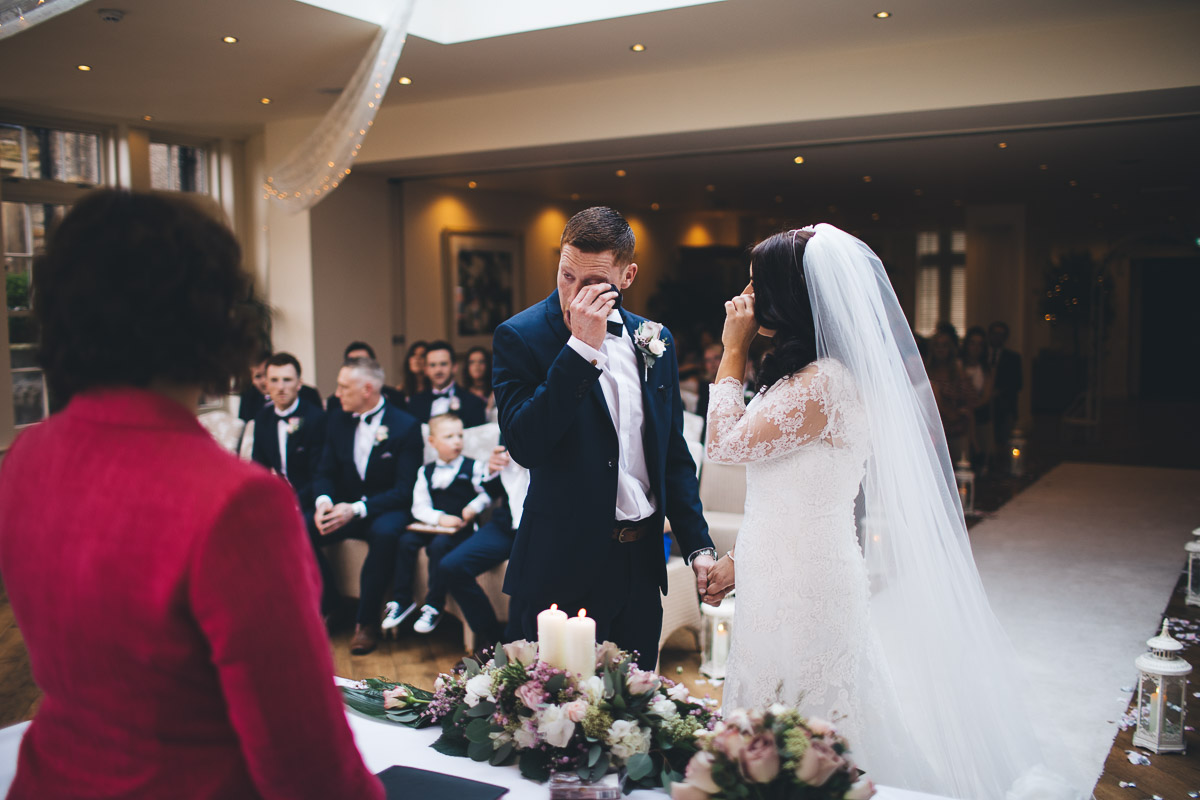 groom wiping a tear away during the ceremony