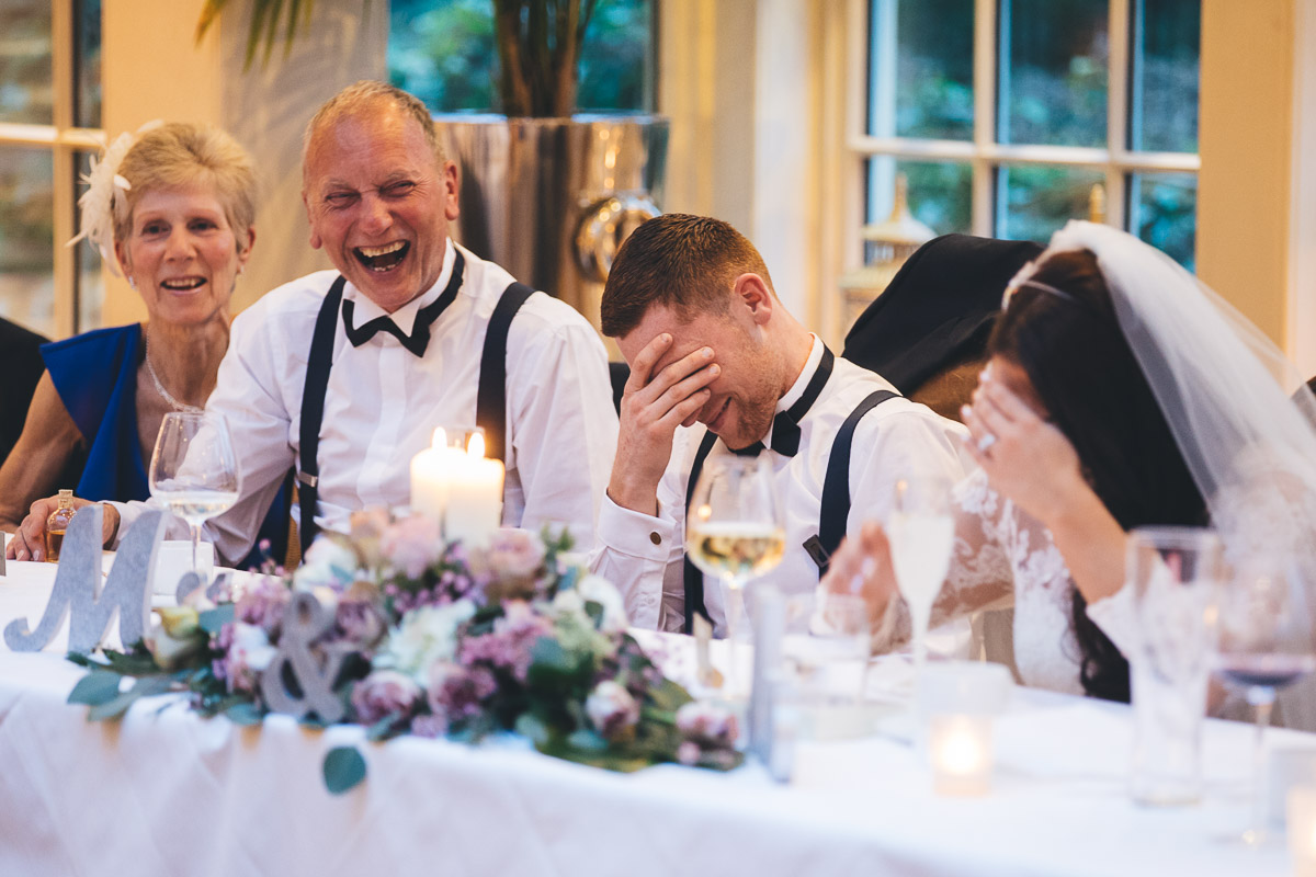 groom with his head in his hands during a funny speech