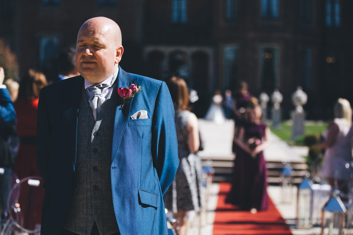 groom waiting for his bride with his eyes closed