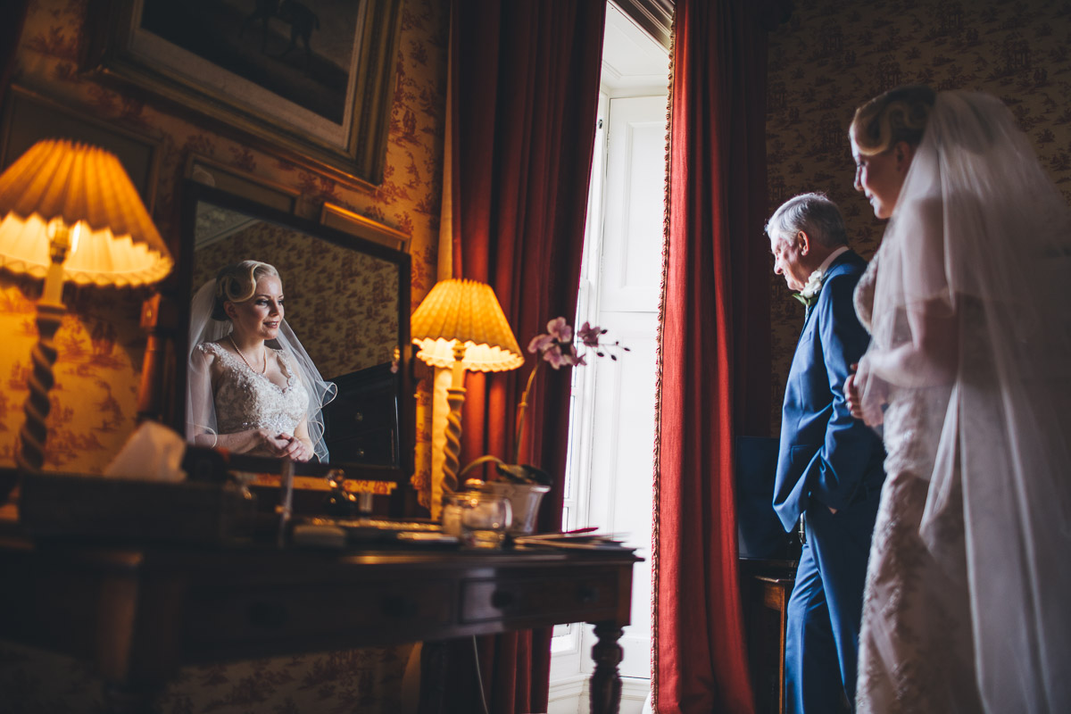 bride looking outside at guest arriving at her wedding