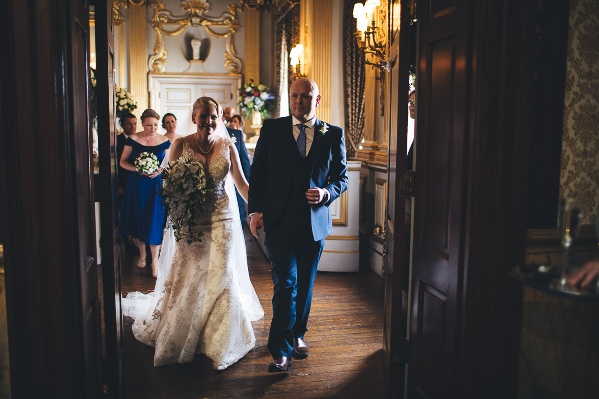 hand in hand the couple leave the stucco ballroom after their ceremony