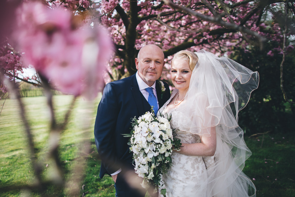 couple pictured by a beautiful blossom tree