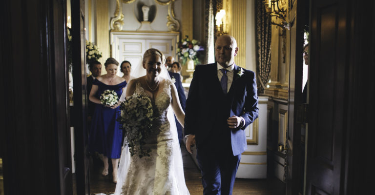 couple leave the stucco ballroom after their wedding ceremony