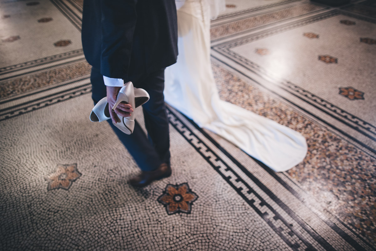 the groom holds his brides shoes in manchester