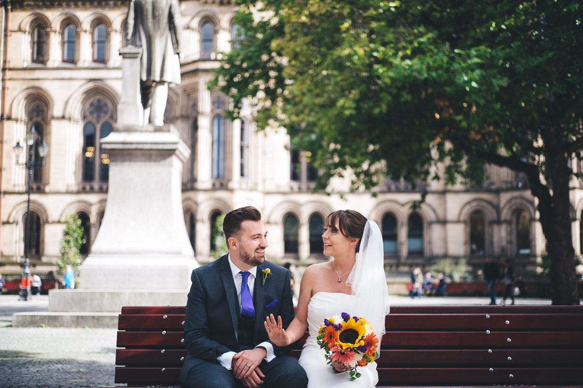 newly weds sit on bench in albert square