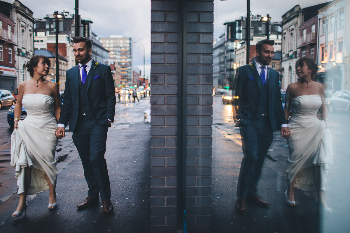 bride and groom walk through manchester