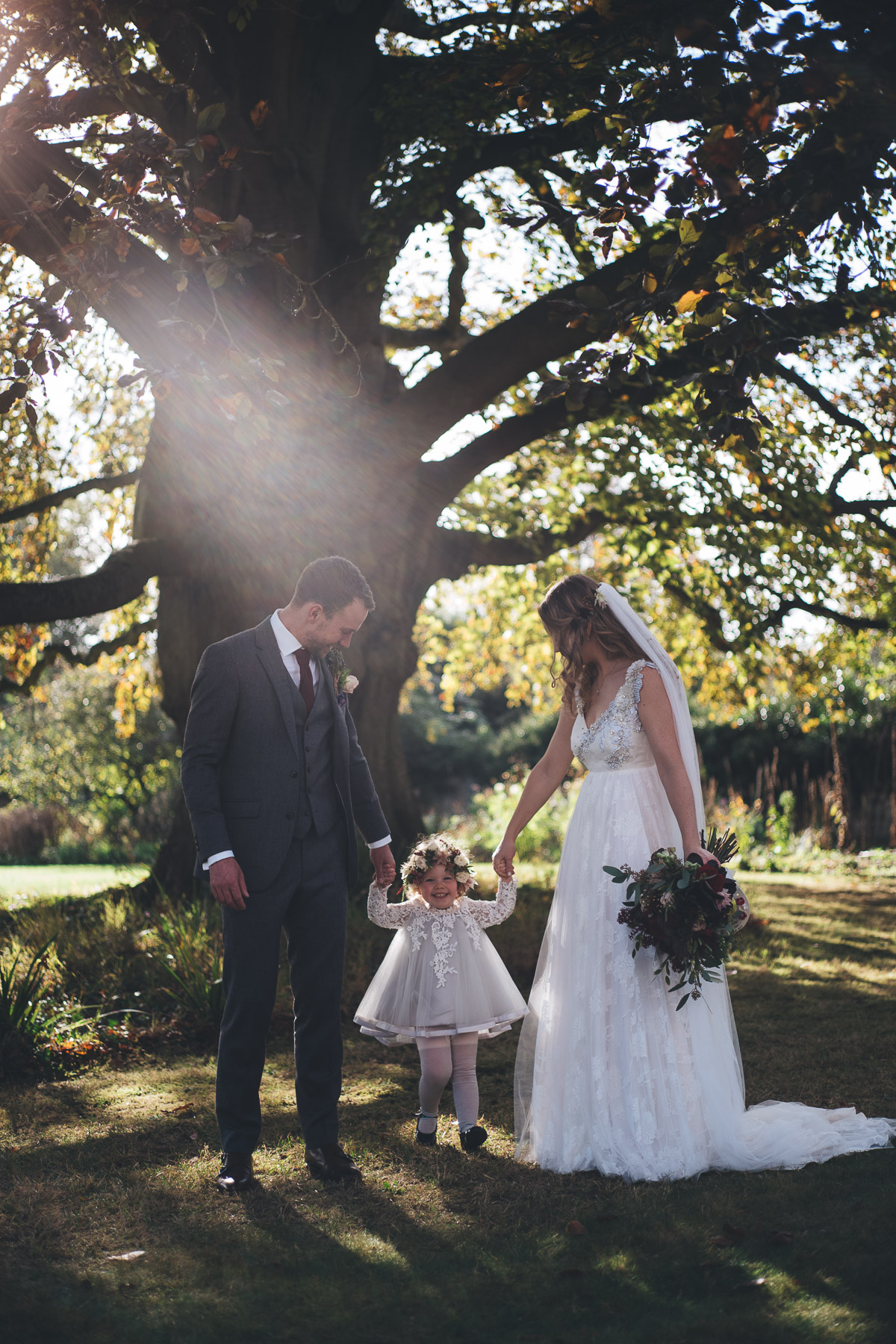 bride and groom with their daughter who is also the flower girl