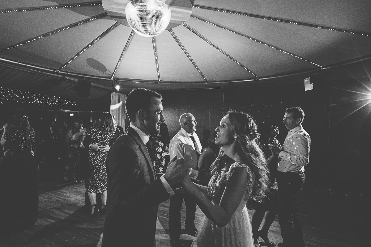 black and white shot of bride and groom dancing