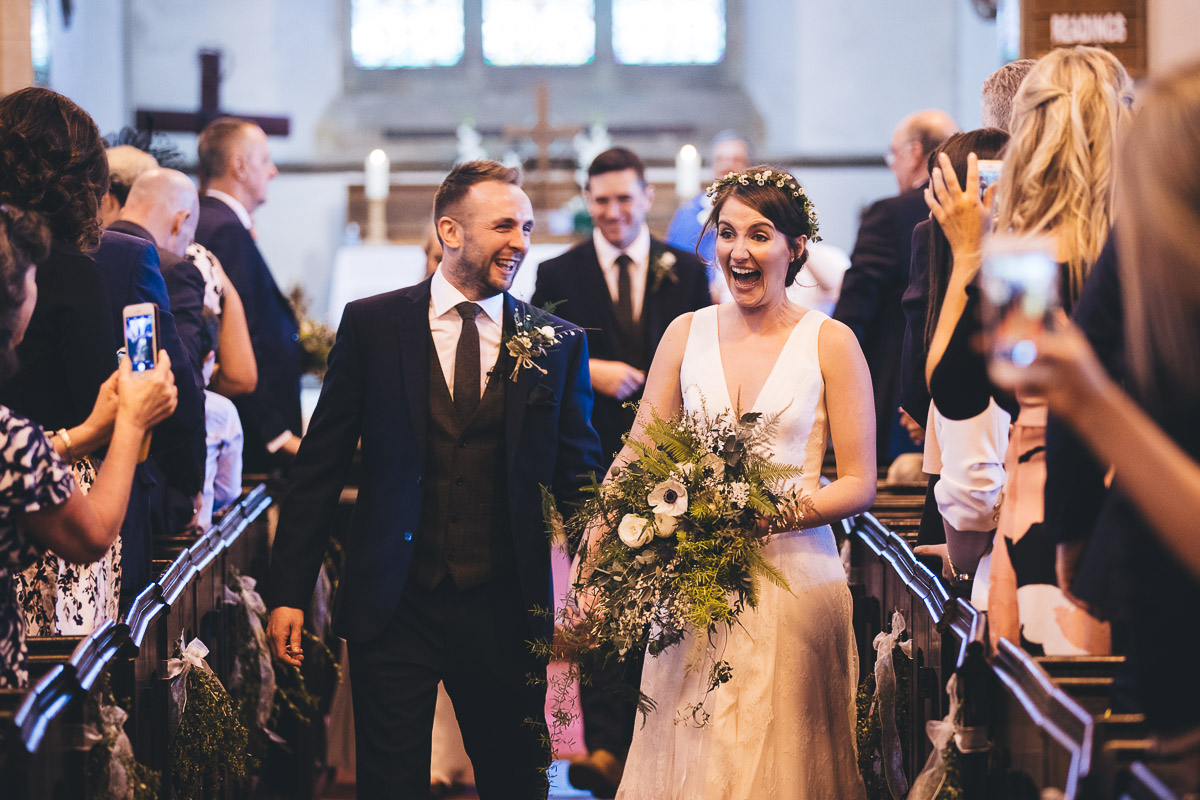 Bride and Groom walking down the aisle Bouquet Smiling Laughing Taking pictures