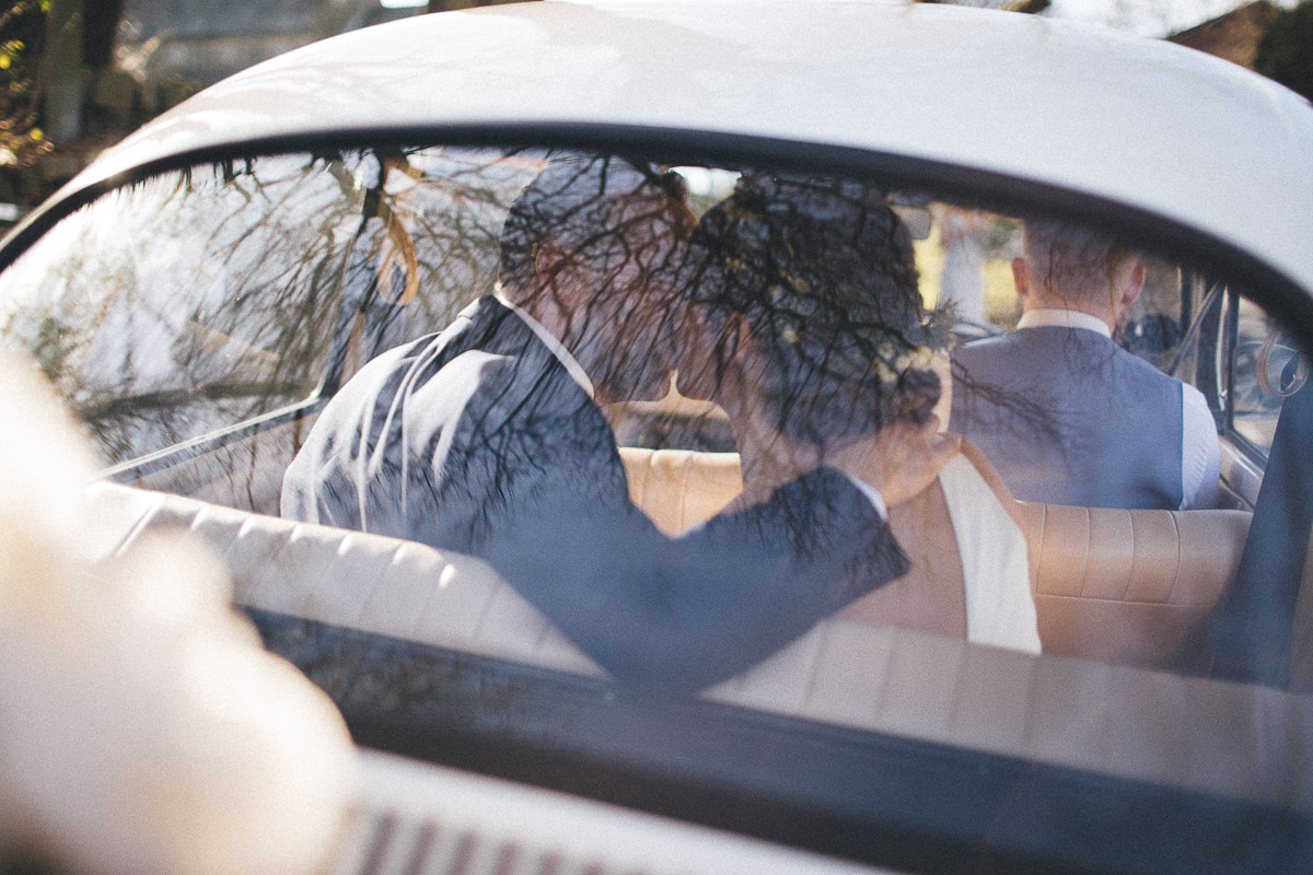 Bride and Groom kiss in the back of the wedding car