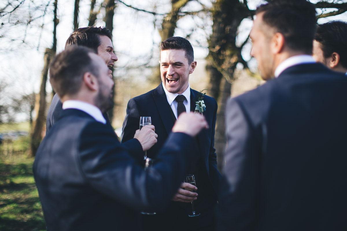 Groomsment laughing champagne glasses