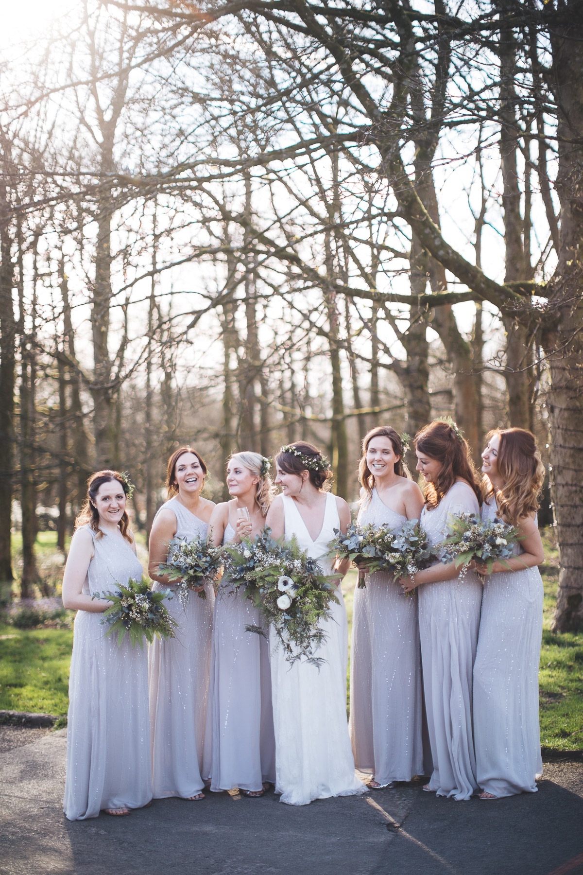 Bride with Bridesmaids Bouquets Trees Sunshine