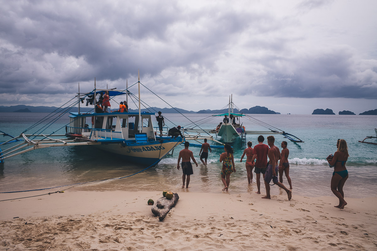 Group getting back on boat from el nido on beach