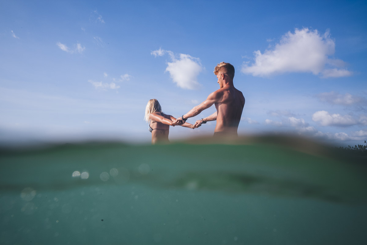 couple hold hands photo shot from under the water
