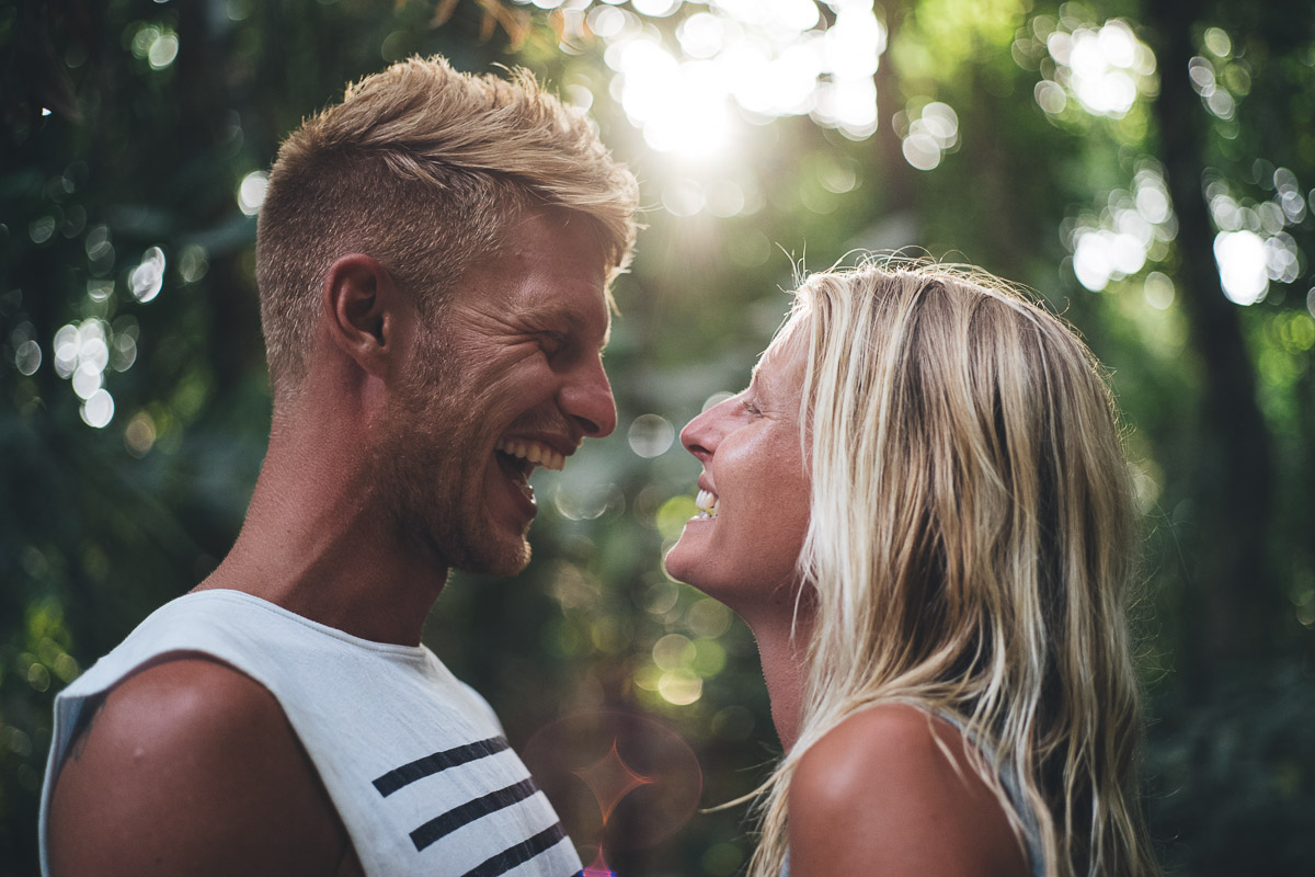 couple laughing at each other back lit with sunshine