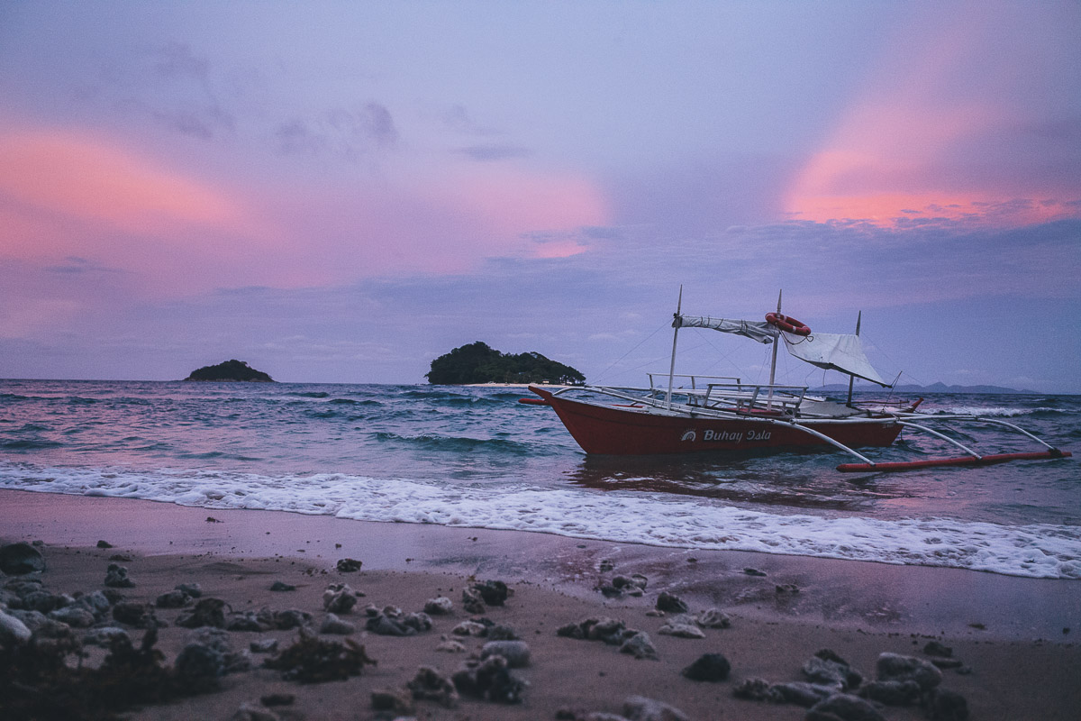 coastal picture of boat on shore at sunset