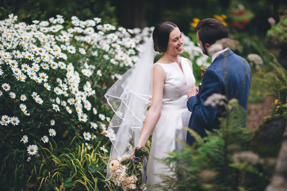 Bride and groom together in a garden full of flowers