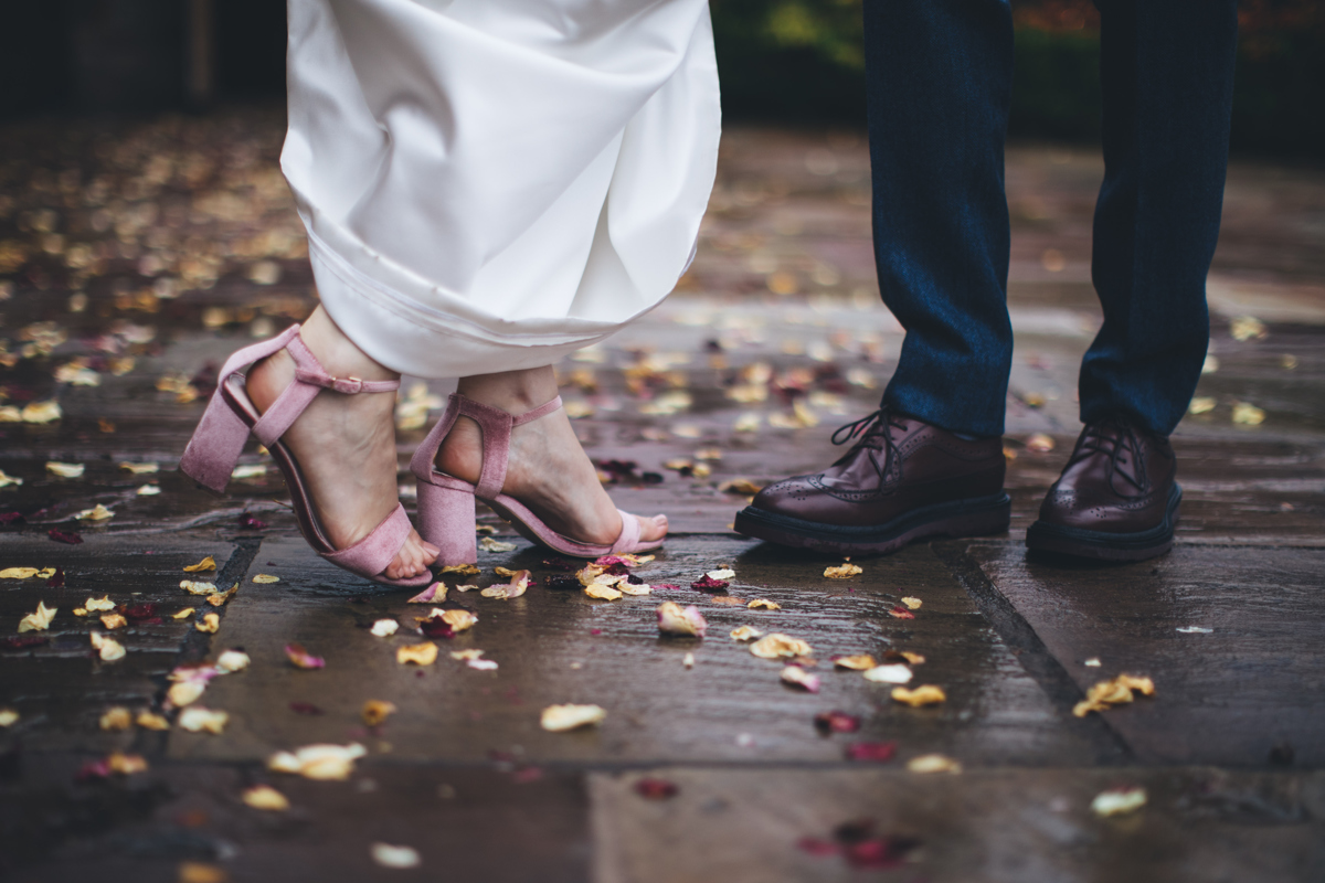 Bride and groom's shoes on a petal covered stone floor