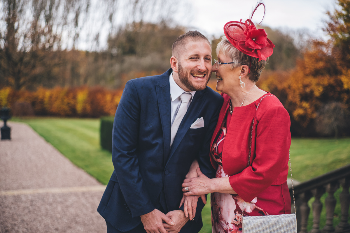 Groom and his mother arm in arm smiling