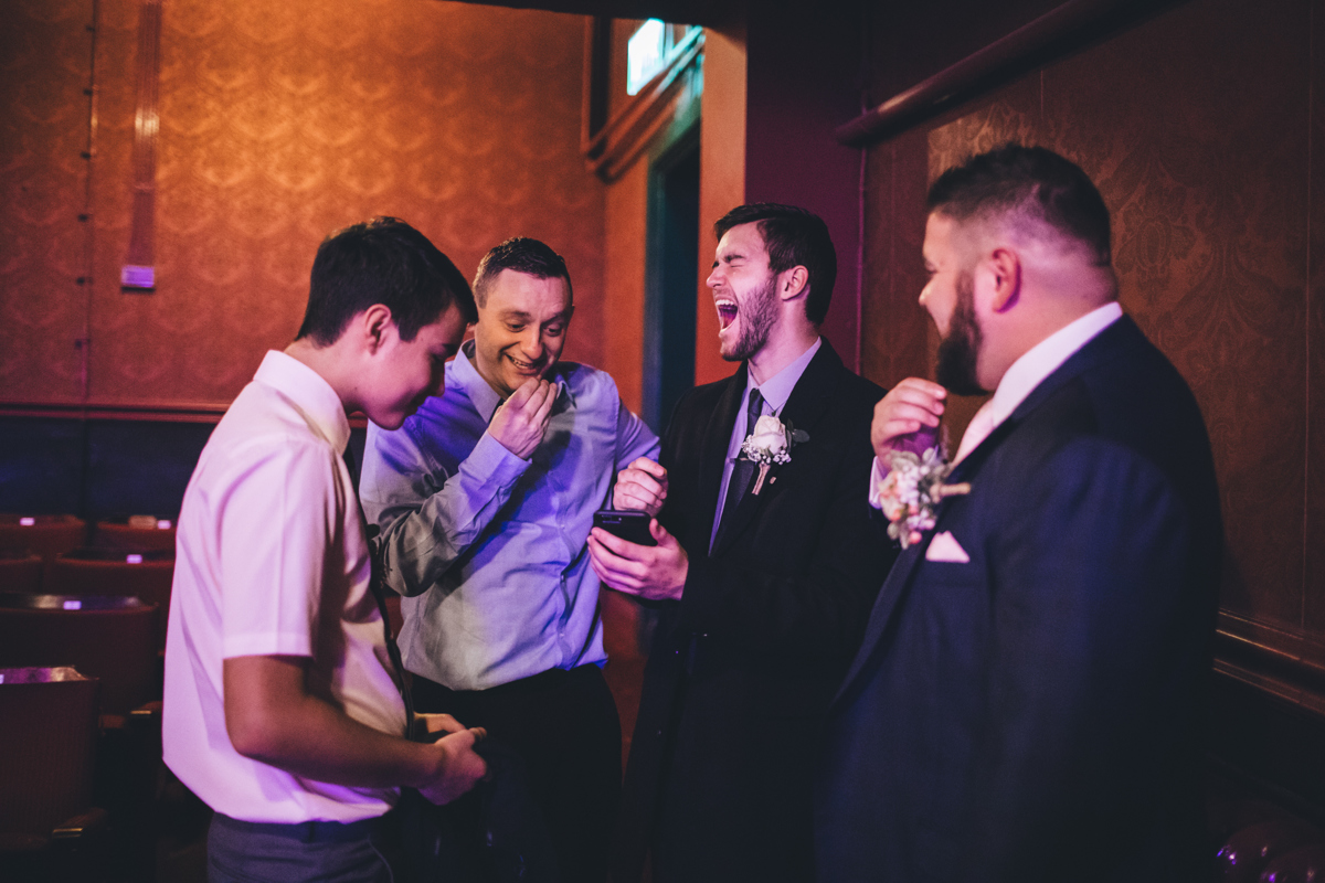 Groom and three friends laughing together