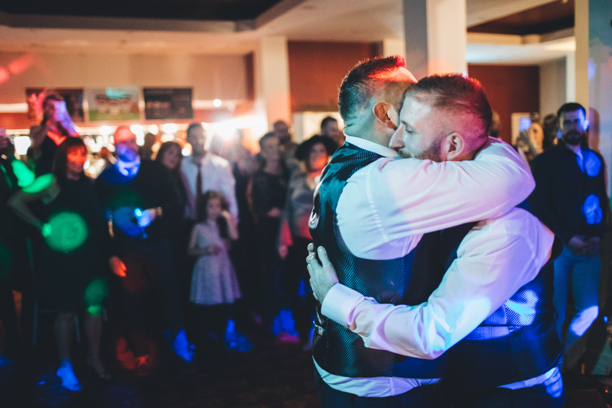 Two grooms hugging during their first dance