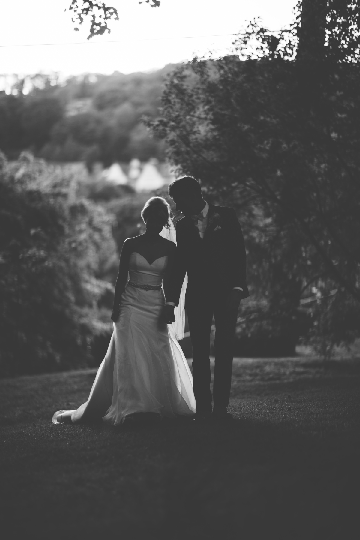 Black and White picture of the Bride and Groom walking throught the garden with trees in the background at Grange Hotel, Cumbria