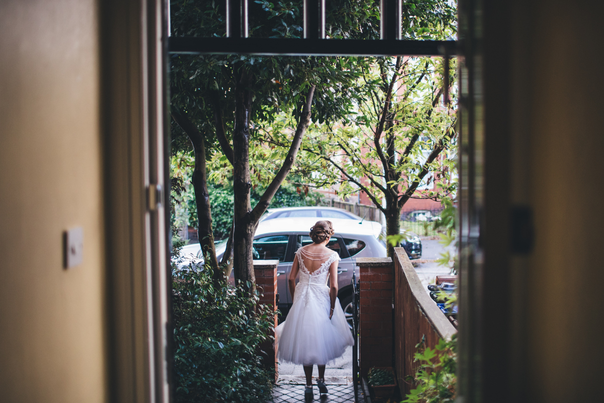 Bride walking down the path towards the wedding car