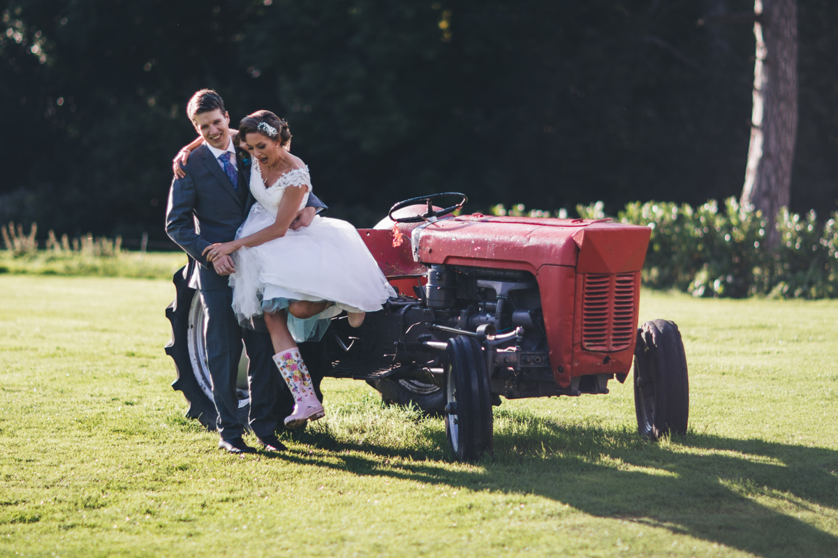 Groom helping bride get off a tractor