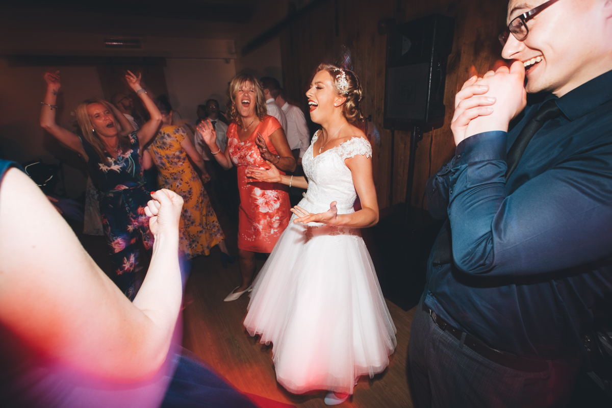 Bride singing along to a song on the dancefloor