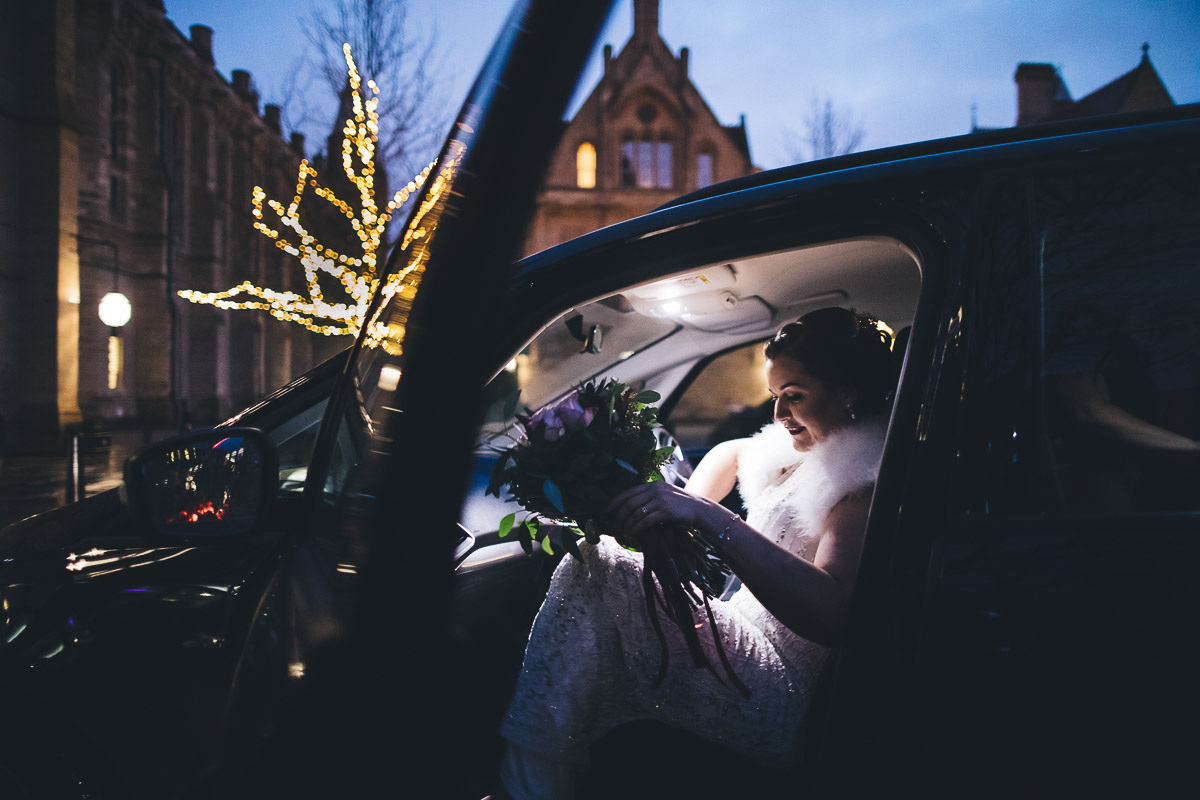 Bride arriving in a car with her bouquet