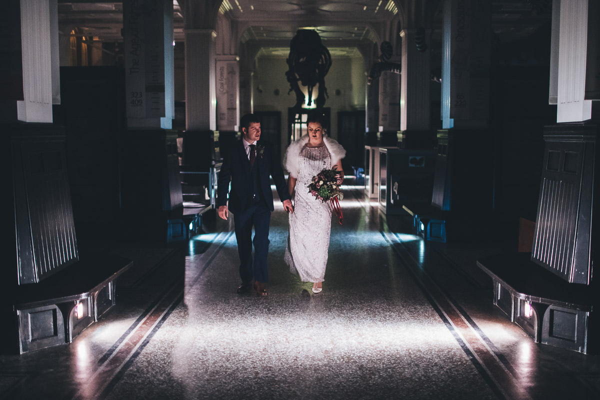 Bride and Groom walking down a corridor in a museum