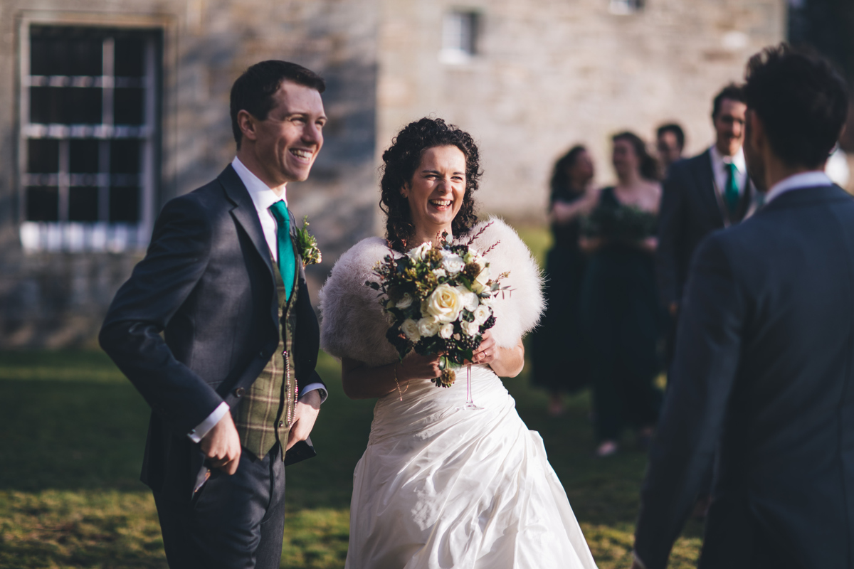 Bride and groom smiling together outside Castle Menzies