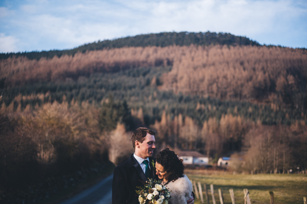 Bride and groom embracing in the scottish countryside