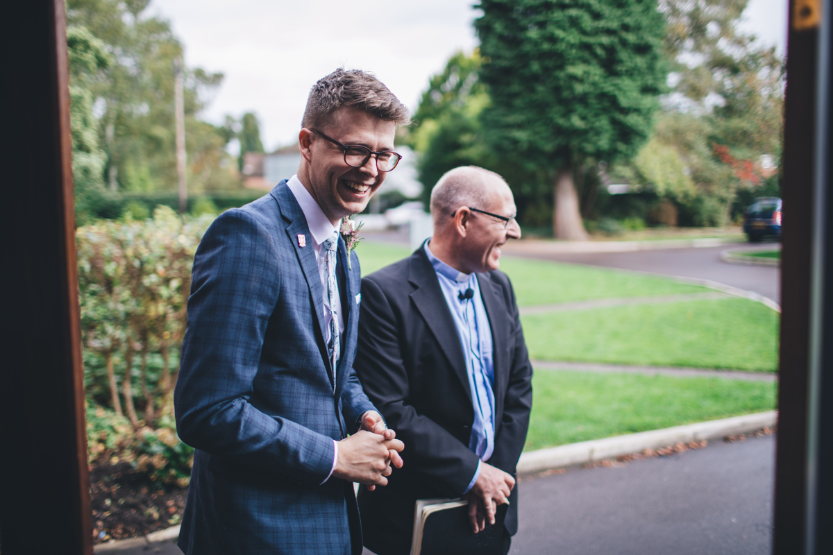 Groom and Priest smiling