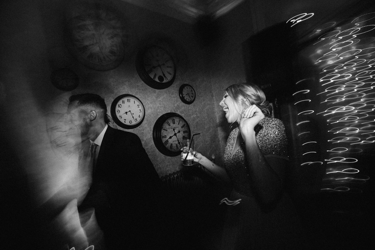 Female dancing with her arms up holding a drink in one hand