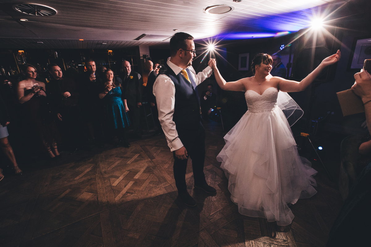 Bride and groom on the dancefloor at King Street Townhouse Manchester holding hands during their first dance