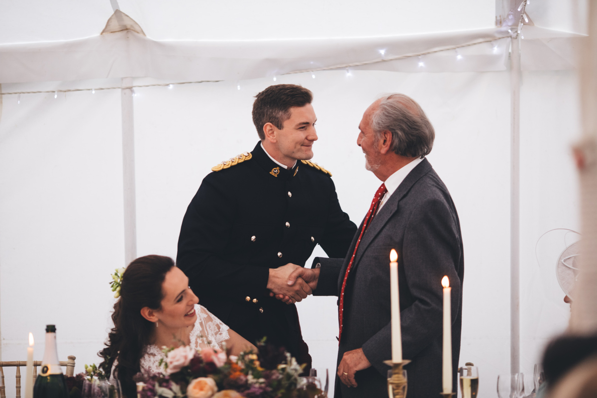 Groom stood shaking his father in law's hand aster the father of the bride speech