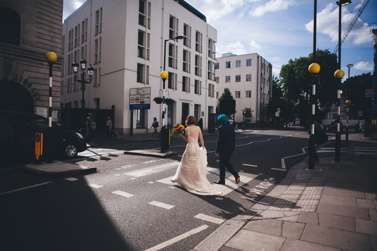 Bride and Groom walking across a pedestrian crossing in central London opposite Porchester Hall