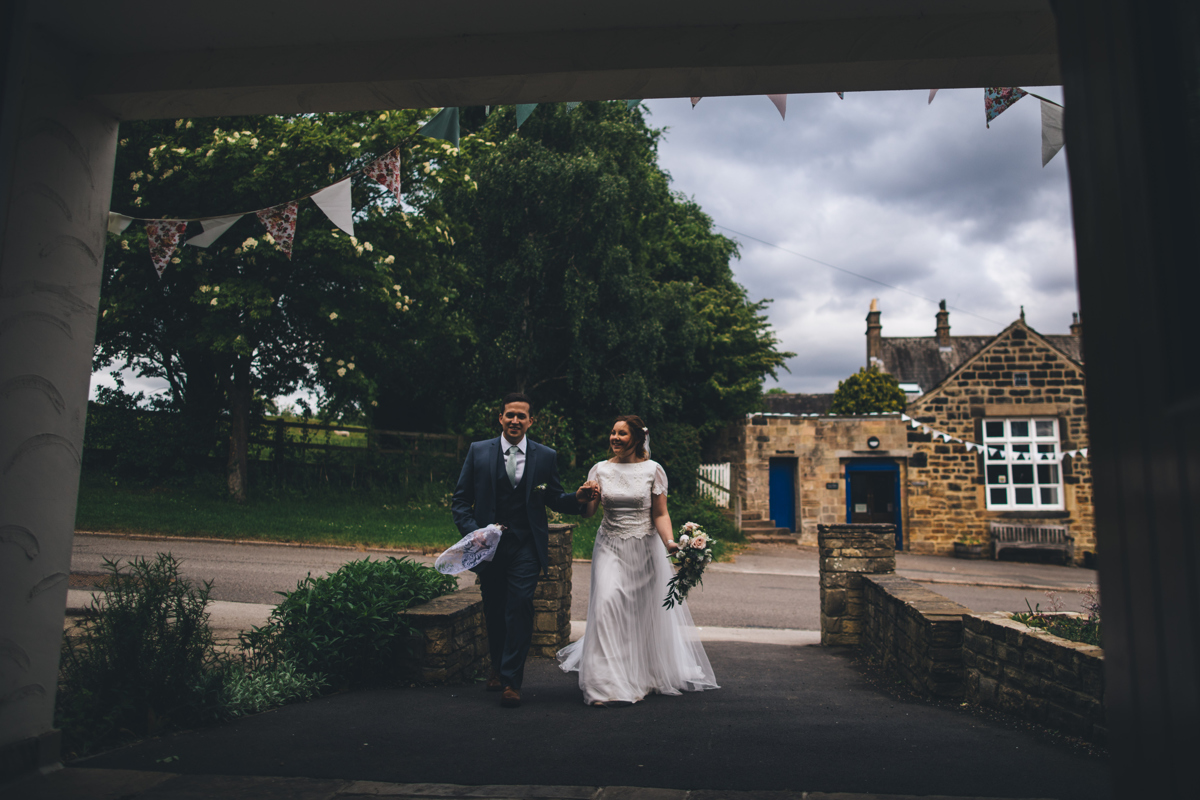 View from the doorway at Bardsey Village Hall, Leeds as the Bride and Groom walk in hand in hand up the pathway