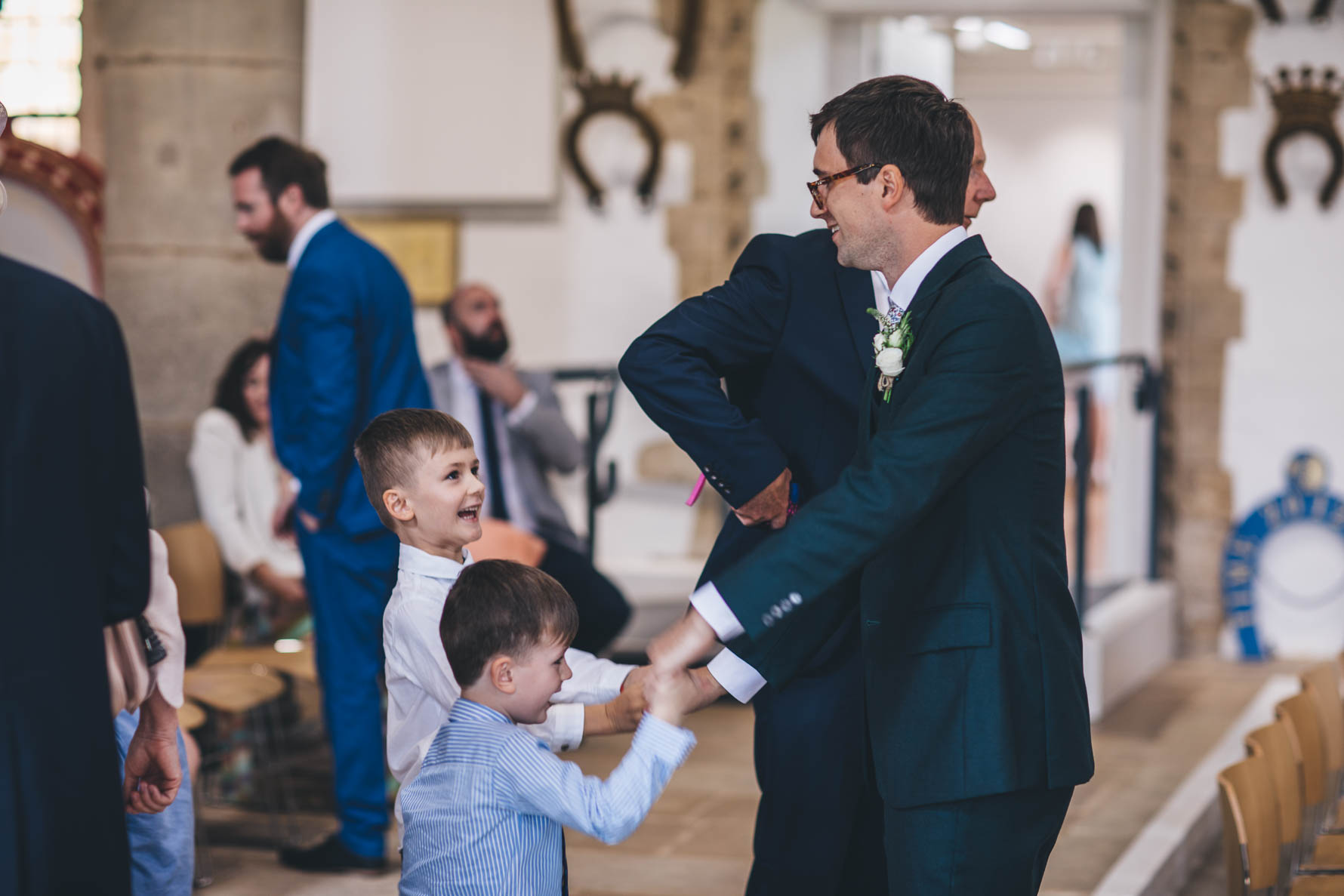 Groom holding the hands of two young boys inside the Great Hall at Oakham Castle
