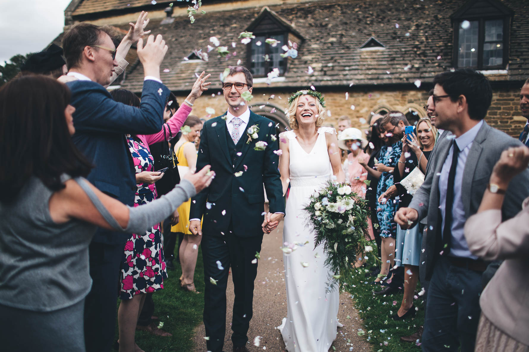 Confetti shot with the bride and groom walking down the path outside the Great Hall at Oakham Castle